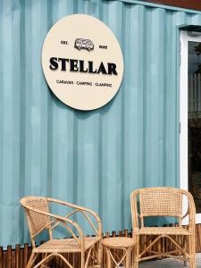 丹那拉打的住宿－Stellar GoldenHill Cameron，两张柳条椅和一个读书的标牌