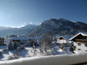 a town covered in snow with mountains in the background at Ferienwohnung Breitenbergblick in Pfronten