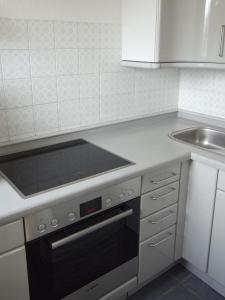 a kitchen with a stove top oven next to a sink at Ferienwohnung Breitenbergblick in Pfronten