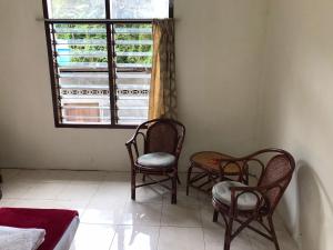 um quarto com três cadeiras e uma janela em Hotel Miranda at Desa Wisata Berastagi em Berastagi