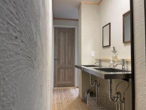 a bathroom with two sinks and a door at 嬉々の屋KIKI Chalet in Hakuba +49 photos
