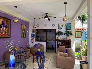 una sala de estar con paredes de color púrpura y sofás en Hotel Balché en Bacalar