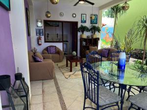 een woonkamer met een glazen tafel en stoelen bij Hotel Balché in Bacalar