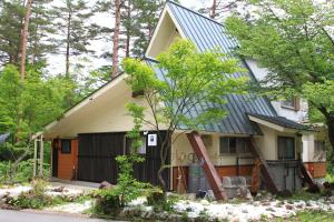 a house with a metal roof on top of it at 嬉々の屋KIKI Chalet in Hakuba