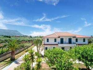 a villa with a garden and palm trees at Flat in residence with swimming pool in Ricadi