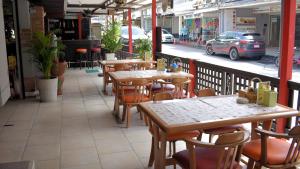 un ristorante con tavoli e sedie in legno su un balcone di Klein Heidelberg Guesthouse a Pattaya North
