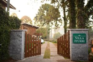 a gate with a sign that reads villa trump at Villa Iturri in Campos do Jordão