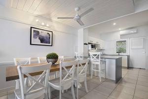 cocina y comedor con mesa y sillas en Hamptons Style Villa 43, en Tangalooma