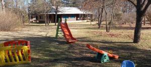 a playground with colorful play equipment in the grass at Cabañas UN LUGAR in Villa General Belgrano
