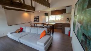 a living room with a couch and a kitchen at Hakuba View Villa in Hakuba
