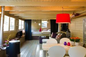 a living room with a bed and a table and chairs at Houseboat Prince-Avalon in Amsterdam