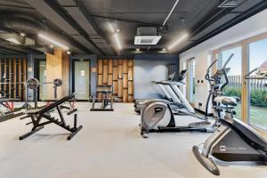 a gym with several treadmills and cardio machines at Downtown Apartments Nadmotławie Riverside & Gym in Gdańsk