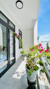 a vase filled with flowers sitting on a balcony at Cô Ba Homestay in Quy Nhon