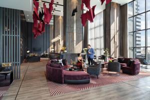 a lobby with couches and tables in a building at Ascott Embassy Sathorn Bangkok in Bangkok