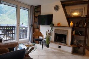 a living room with a fireplace and a television at Window on the mountains in Breuil-Cervinia