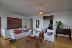 a living room with a couch and two chairs at Casa do Lado in Povoação
