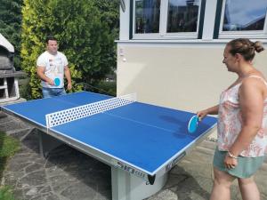 a man and a woman standing next to a ping pong table at modern&renovated - Hotelpension Oberauer Wagrain in Wagrain +51 photos