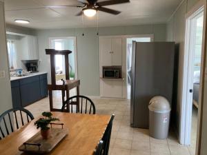 a kitchen and dining room with a table and a refrigerator at Waterfront cottage at St. Charles Bay, boat ramp in Rockport