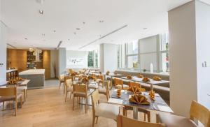 a restaurant with tables and chairs and a kitchen at Fraser Residence Sudirman Jakarta in Jakarta