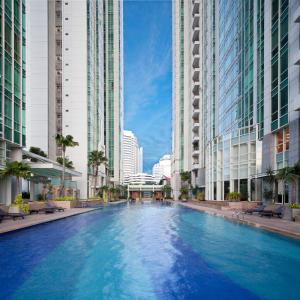 ein großes Schwimmbad in einer Stadt mit hohen Gebäuden in der Unterkunft Fraser Residence Sudirman Jakarta in Jakarta
