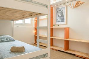 Le Repaire - 2 chambres avec balcon في مارسيليا: غرفة نوم مع سرير بطابقين ورفوف