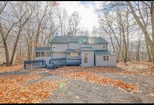 a large house in the woods with leaves on the ground at Cabin at poconos,spa-room with Hot tub, grill, fire pit in Miami