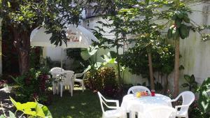 Calvary house في أنتيغوا غواتيمالا: حديقة بها طاولات وكراسي بيضاء وشجرة