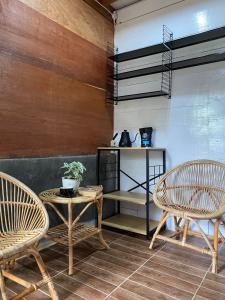 LhongaにあるSaho Coffee & Roomsの椅子2脚、テーブル1台、棚1台が備わる客室です。
