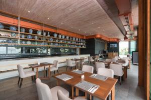 ein Restaurant mit Tischen und Stühlen und eine Bar in der Unterkunft My Beach Resort Phuket in Panwa Beach