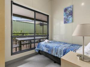 a bedroom with a bed and a balcony with a table at Ingenia Holidays Noosa North in Tewantin