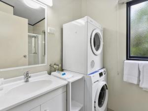 a white bathroom with a washing machine and a sink at Ingenia Holidays Noosa North in Tewantin