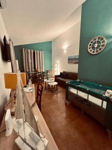 - un salon avec une table et une horloge murale dans l'établissement Rif Holiday Home Stagnone Marsala, à Birgi Vecchi