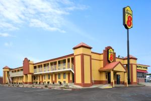 a large yellow building with a fast food restaurant at Super 8 by Wyndham Indianapolis-Southport Rd in Indianapolis