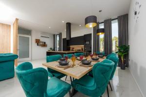 a dining room with a wooden table and green chairs at Villa Porta Novalja in Novalja