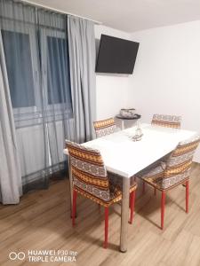 a dining room table with chairs and a tv at Perfekte Rast in Sibiu