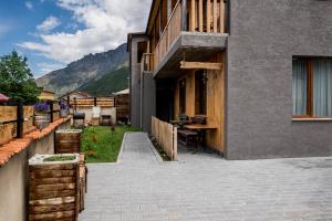 ein Haus mit einem Gehweg neben einem Gebäude in der Unterkunft Hotel Jimla in Kazbegi