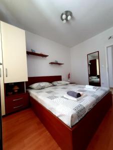 a bedroom with a large bed with a mirror at Apartments Tri sestrice in Sveta Nedelja