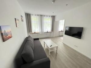 ein Wohnzimmer mit einem Sofa und einem TV in der Unterkunft Zentrale und schöne Ferienwohnung II in Lübeck