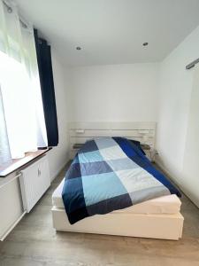 a bedroom with a bed with a blue and white blanket at Zentrale und schöne Ferienwohnung II in Lübeck