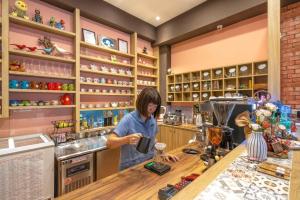 Una donna in piedi al bancone in cucina di Feather and Flowers Homestay a Ji'an