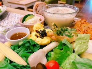 a plate of food with lettuce and vegetables and a drink at Feather and Flowers Homestay in Jian