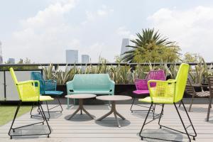 un groupe de chaises et de tables sur une terrasse dans l'établissement Capitalia Anzures Polanco, à Mexico