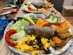 a plate of breakfast food on a wooden table at Feather and Flowers Homestay in Ji'an