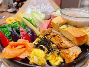 um prato de alimentos com vegetais e pão sobre uma mesa em Feather and Flowers Homestay em Jian
