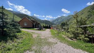 a gravel road leading to a house in a mountain at Гостевой дом Коль-тор in Kegeti