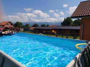 a large blue swimming pool on the side of a house at Pensiunea Sonia in Cârțișoara