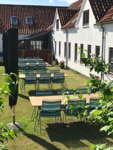 a row of tables and chairs in a yard at Ibsens Gaard in Ebeltoft