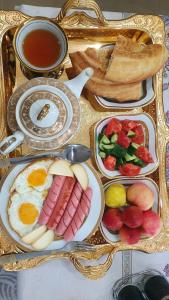 una bandeja de alimentos para el desayuno en una mesa en Fayzli GuestHouse, en Tashkent
