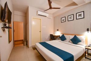 a bedroom with a large bed with blue pillows at FabHotel Azure Sky Hussainpur in Kolkata