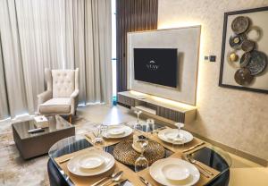 a living room with a table and a television at STAY BY LATINEM Luxury 1BR Holiday Home CV A2605 near to Burj Khalifa in Dubai